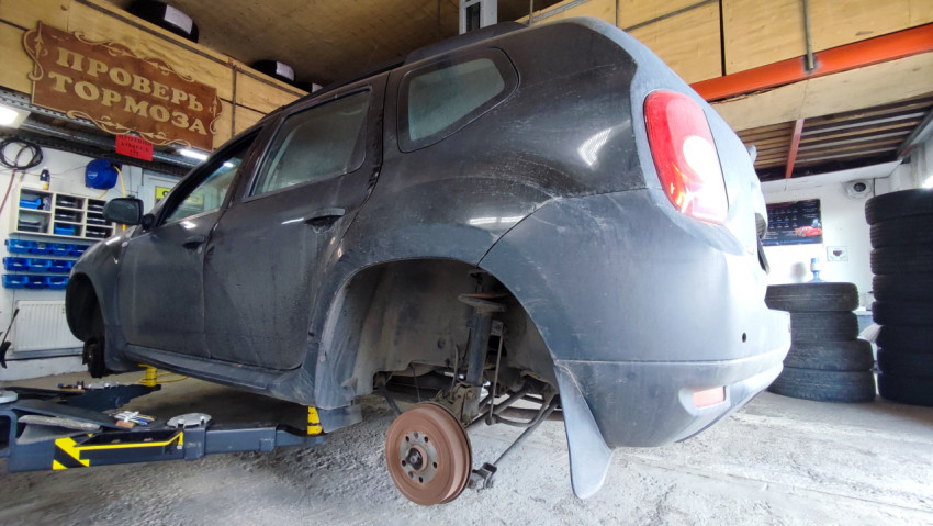Ремонт задней части автомобиля на подъёмнике в сервисном цехе