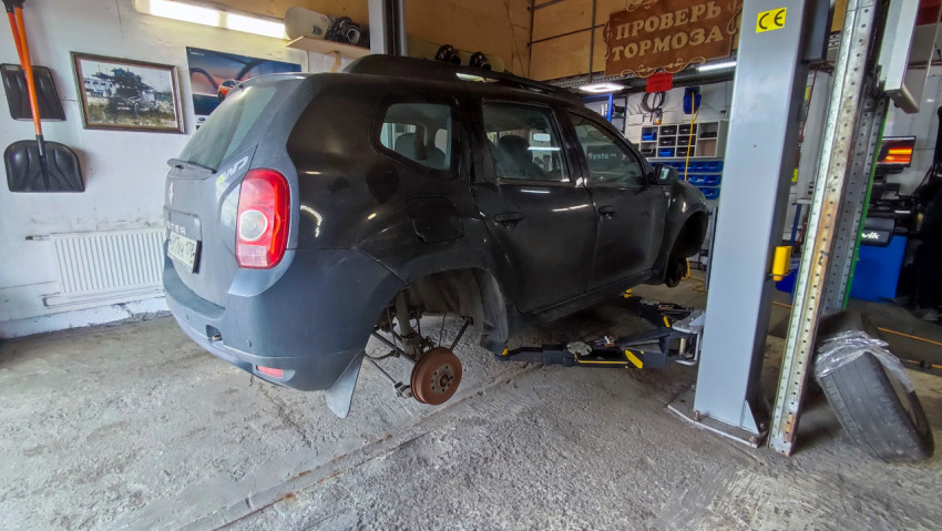 Автомобиль на подъёмнике без задних колёс в автосервисе