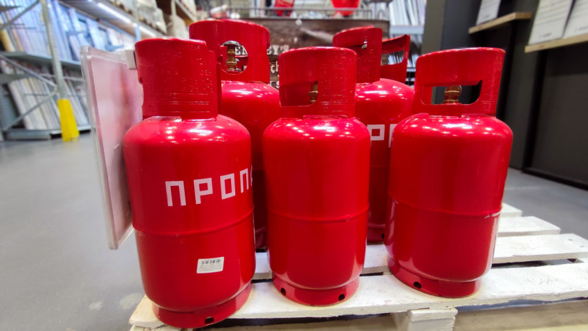 Ряд газовых баллонов пропана на паллете в магазине