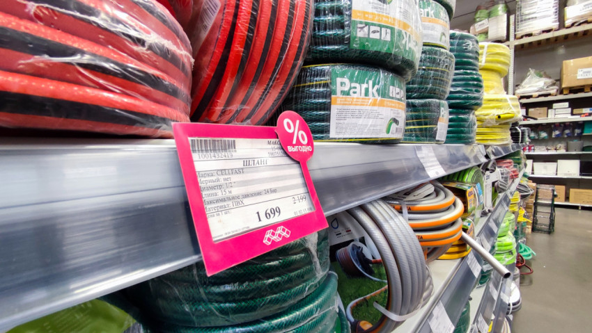 Садовые поливочные шланги на стеллаже магазина