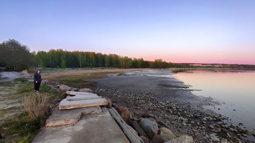 Низкий уровень воды у берега реки на закате