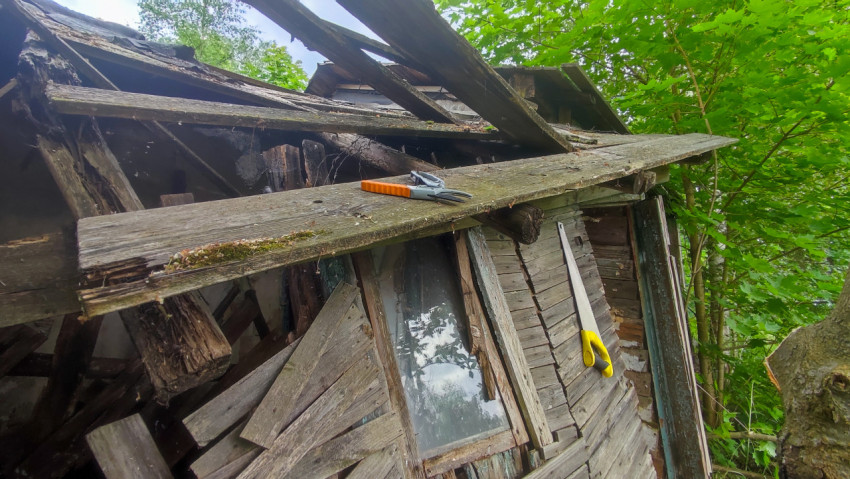 Завал досок и инструментов на фасаде заброшенного деревянного дома