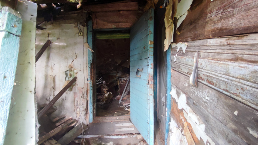 Интерьер с голубой дверью в аварийном деревянном доме