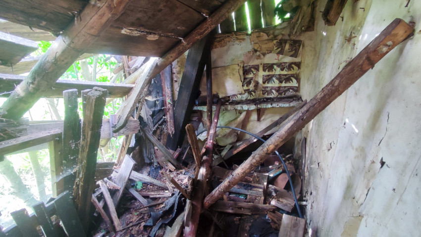 Завал из досок и обрушенных балок в заброшенном доме