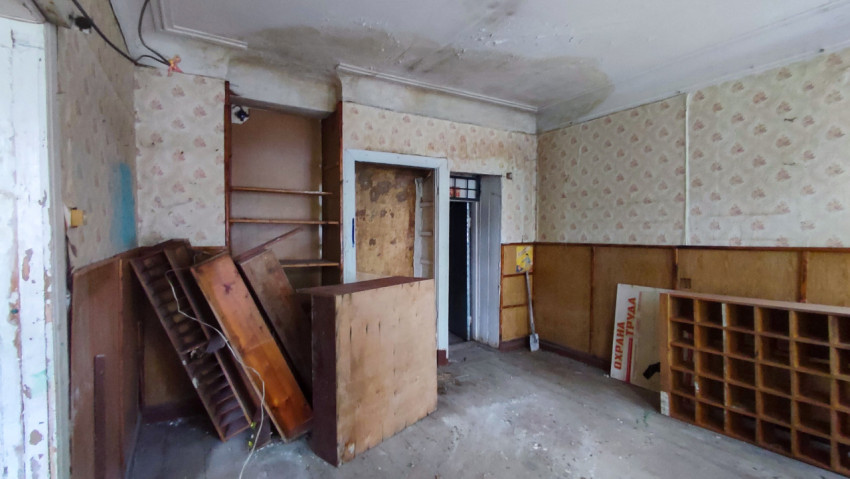 Пустая комната с разобранной мебелью и стендом «Охрана труда»