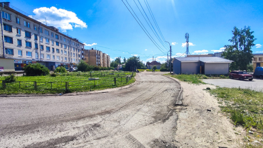 Панорама дворового проезда у жилых домов, зеленого участка и хозяйственных построек