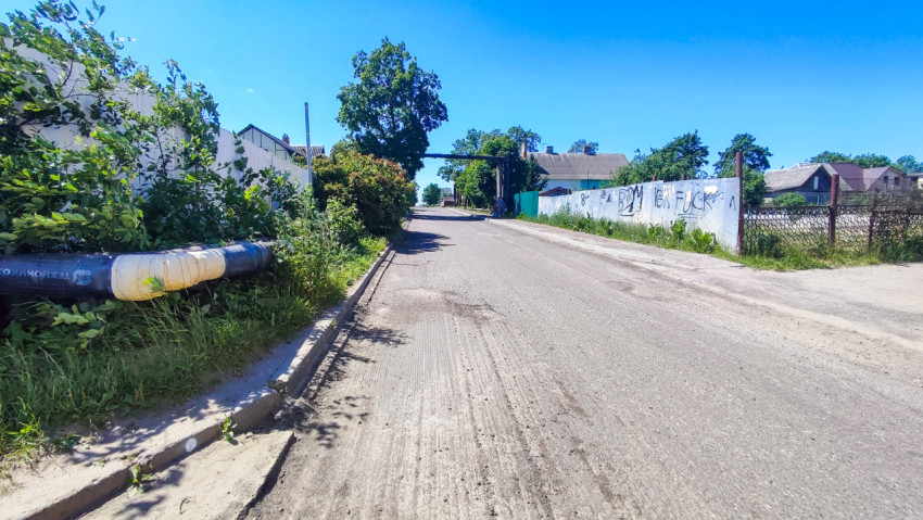 Пустая дорога с надземным трубопроводом вдоль обочины