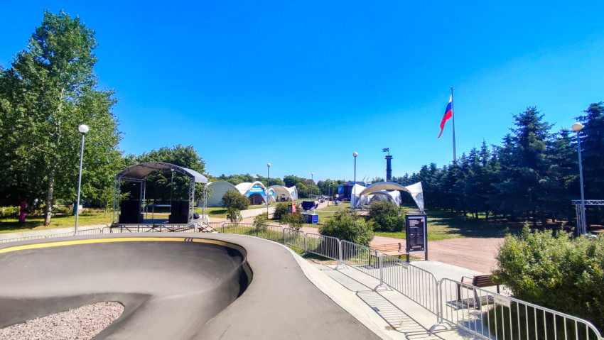 Фестивальная площадка с памп-треком, сценой, шатрами и флагом России в парке