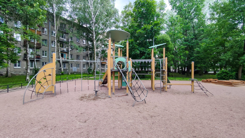 Игровой комплекс с сетками и горкой на площадке у жилого дома