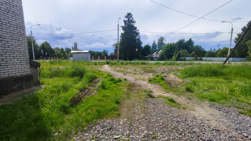 Грунтовая тропа из щебня к дороге и остановочному павильону рядом с зелёной зоной