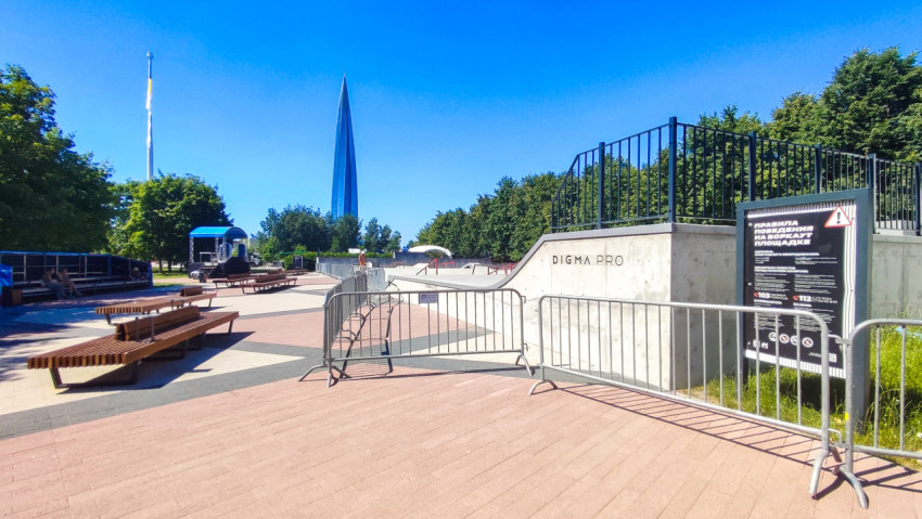 Площадь у скейтпарка с лавками, барьерами и видом на «Лахта Центр» в ясный день