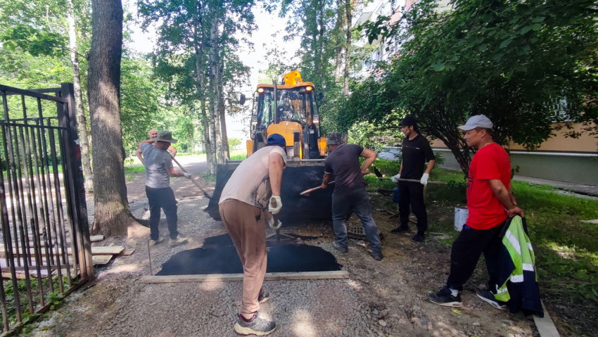Асфальтирование дорожки во дворе с рабочими и экскаватором-погрузчиком JCB