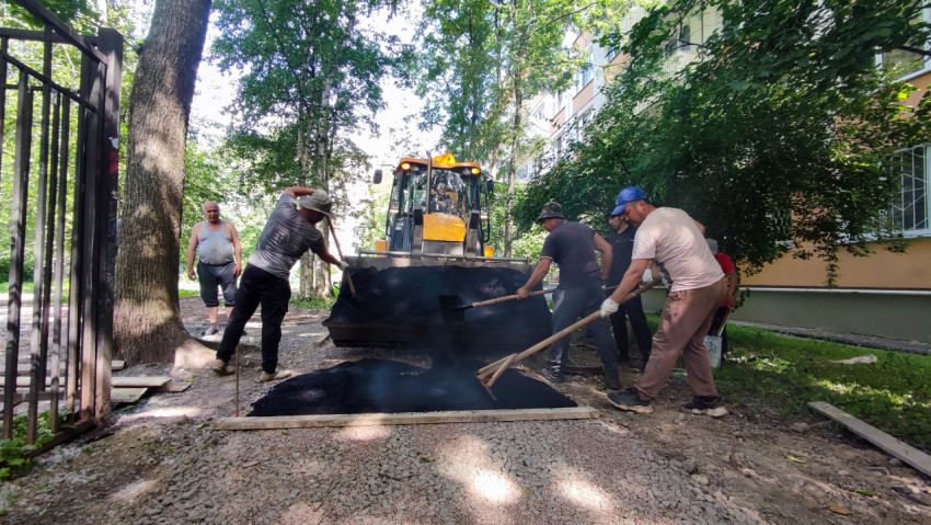 Укладка асфальта в прямоугольной карте рядом с подъездом и деревьями