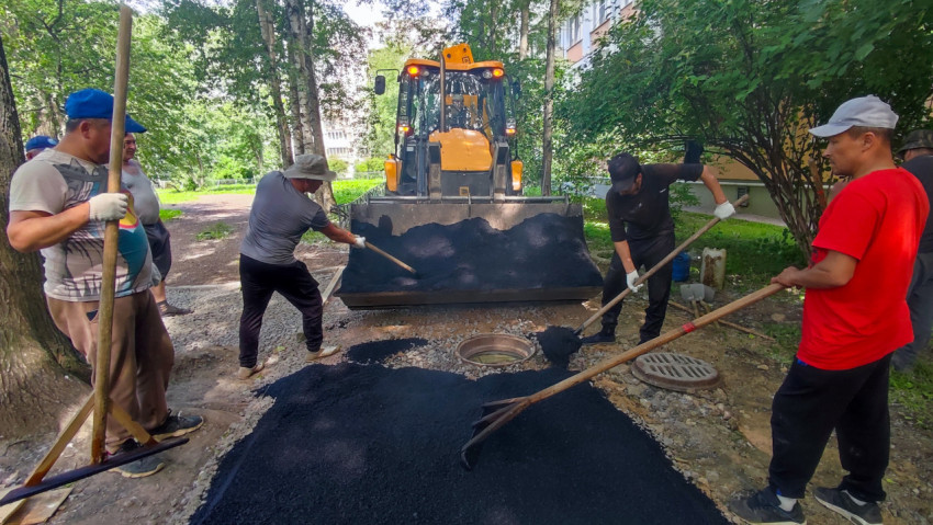 Бригада готовит асфальтирование возле люка и решётчатой крышки колодца