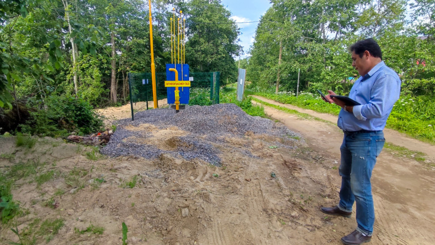 Инженер с планшетом на площадке монтажа газового оборудования в лесу