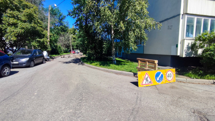 Дворовая дорога у жилого дома с временным щитом дорожных работ и ограничением скорости 40