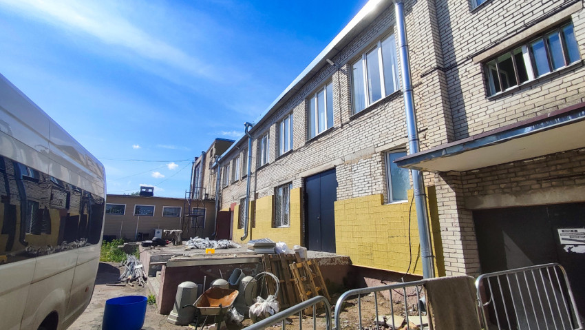 Двор стройплощадки у кирпичного здания с утеплением фасада