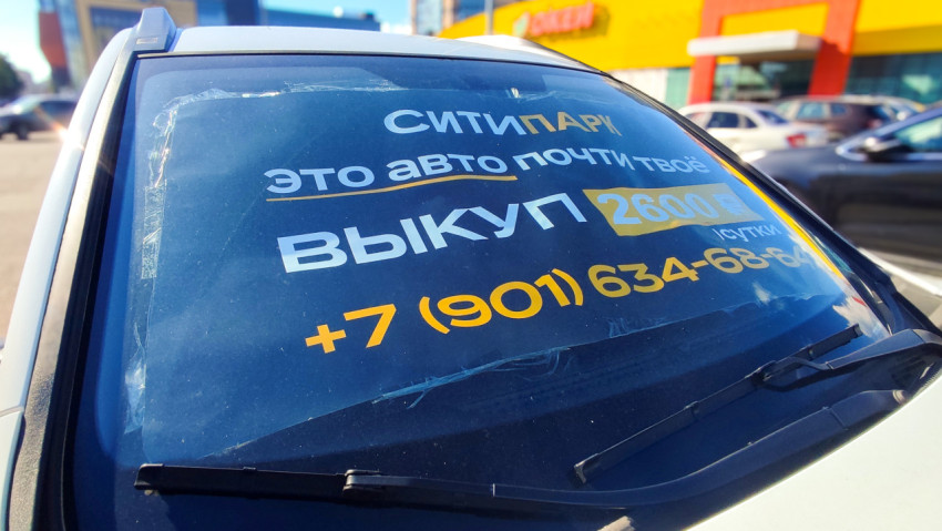 Наклейка «Ситипарк» на лобовом стекле на фоне гипермаркета «ОКЕЙ» и парковки