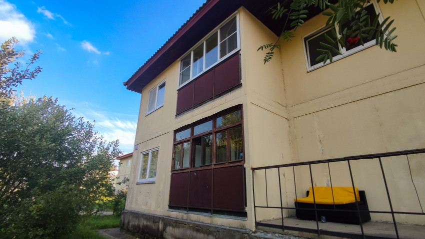 Фасад низкого жилого дома с застеклёнными лоджиями и входной группой