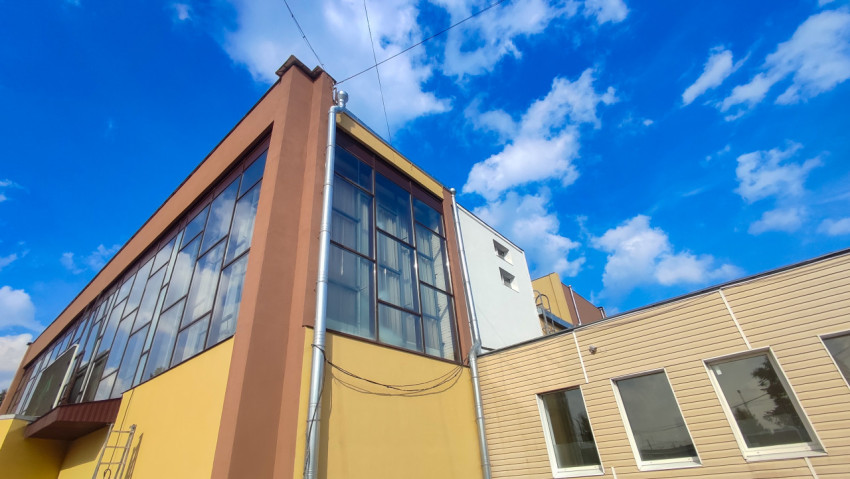 Фрагмент фасада общественного здания с витражными окнами и водостоками