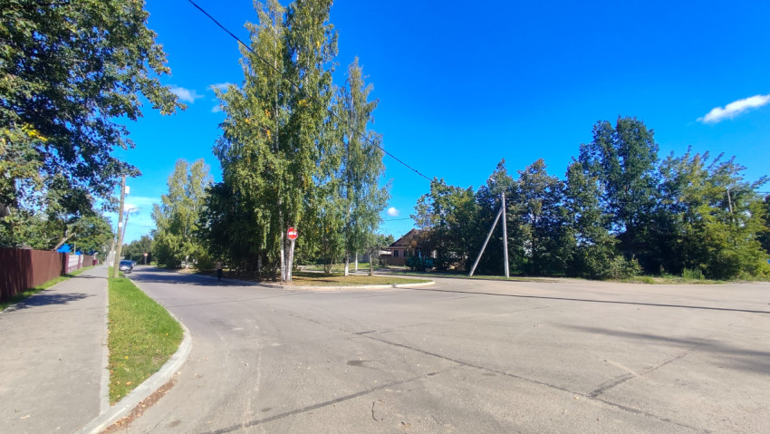 На столбе у развилки висит знак «Въезд запрещён» рядом с тротуаром и газоном