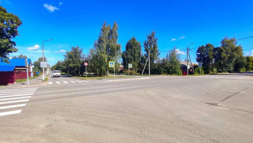 Широкий перекрёсток с несколькими знаками перехода, «кирпичом» и белой маршруткой вдалеке