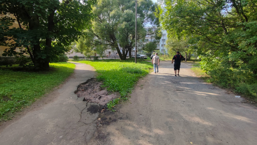 Повреждённый асфальт во дворе с вырезанным участком и оголённым основанием