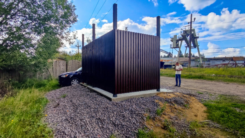 Металлическая хозяйственная постройка на бетонном основании на промышленной территории