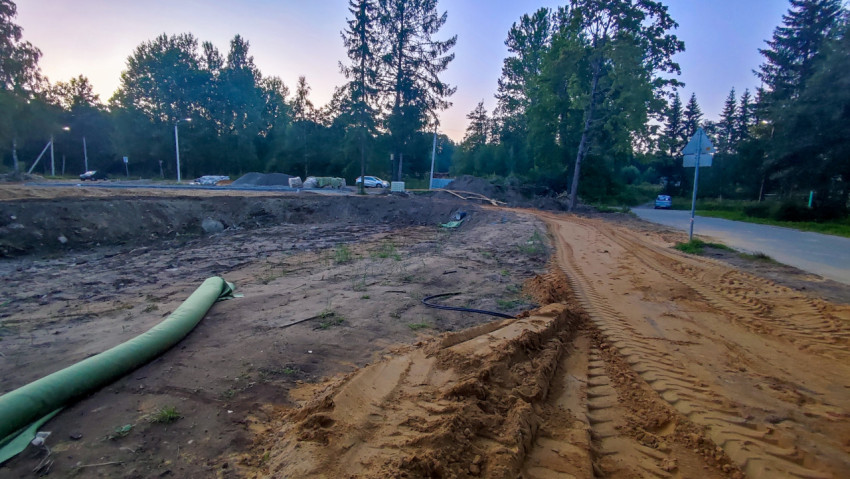 Котлован и песчаный подъезд у асфальтированной дороги во время дорожных работ