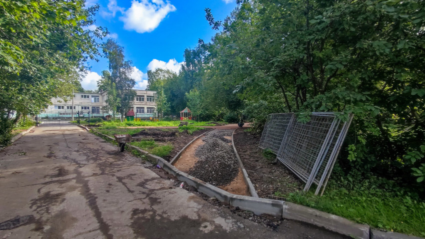 Устройство извилистой пешеходной дорожки с бордюрами и щебёночной отсыпкой во дворе рядом с деревьями