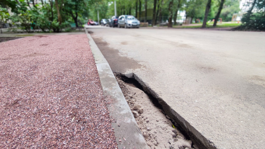 Разрушенная кромка асфальта и пустота под дорожным покрытием крупным планом