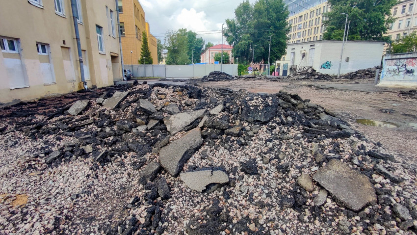 Куча асфальтового лома и щебня на площадке ремонта дворового проезда