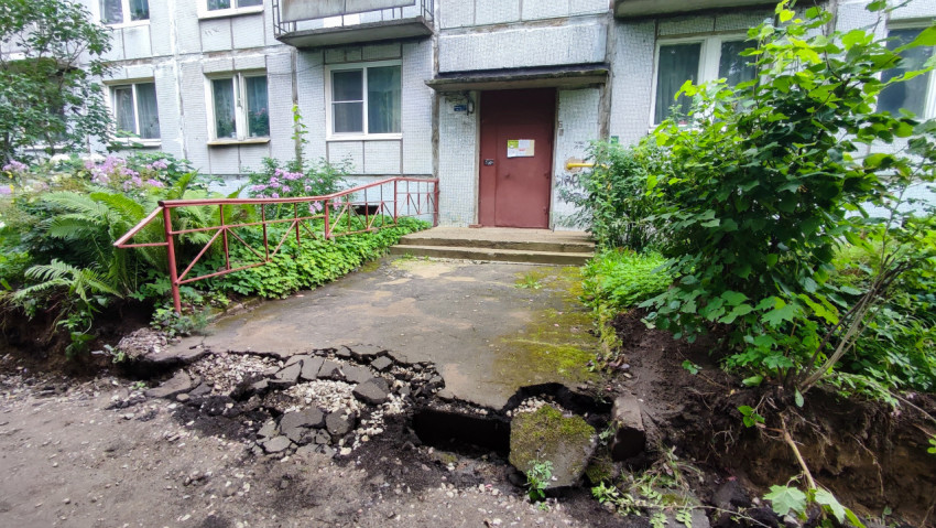 Трещины и провал покрытия у подъезда с красной дверью