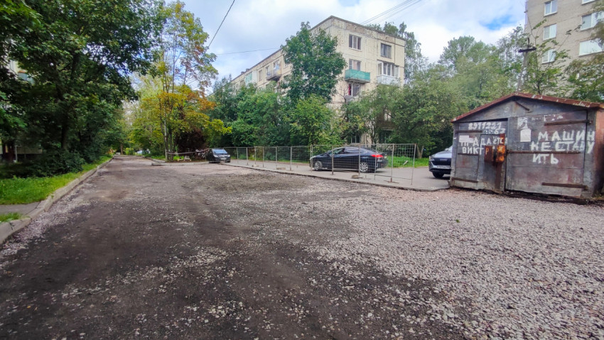 Дворовой проезд с щебёночным основанием и временным ограждением при ремонте
