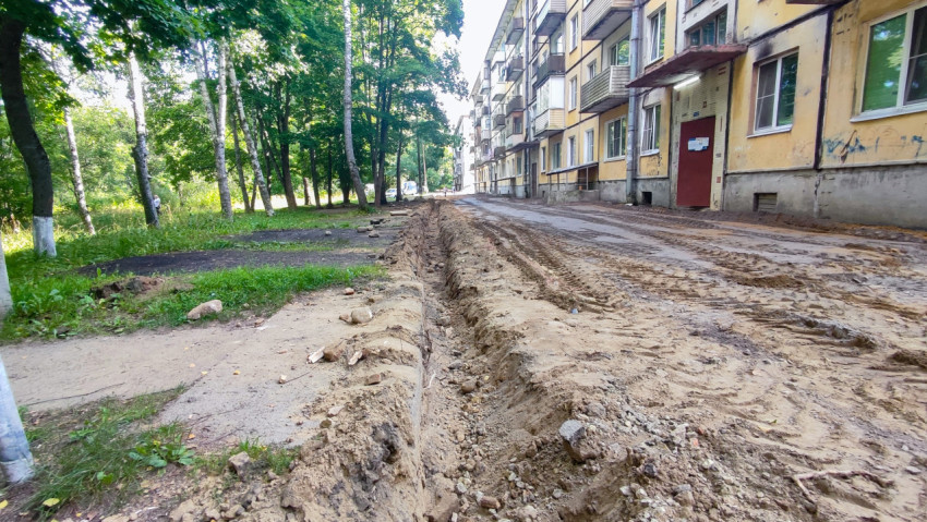 Ремонт дворовой дороги вдоль многоэтажек с траншеей у кромки проезда и песчаным основанием