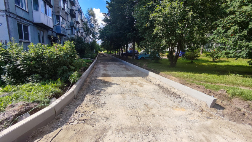 Песчано-щебёночное основание дворового проезда с установленными бордюрами вдоль жилых домов