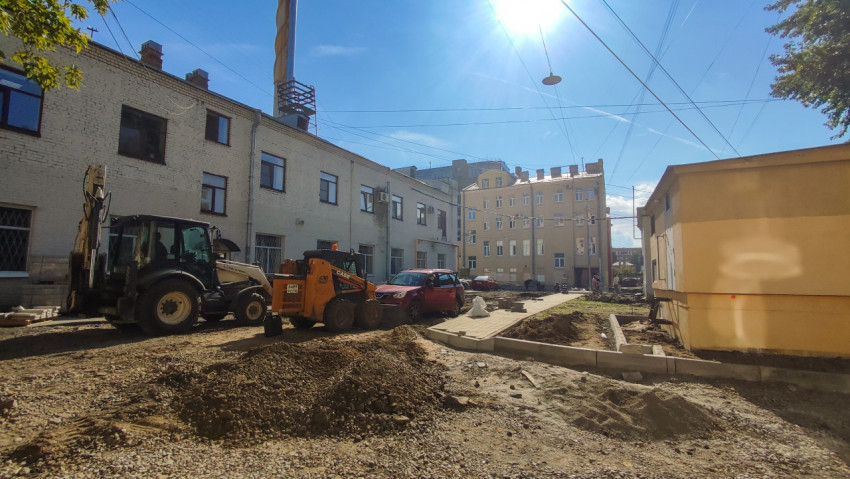 Дворовая стройплощадка с погрузчиком CASE, траншеями и укладкой плитки