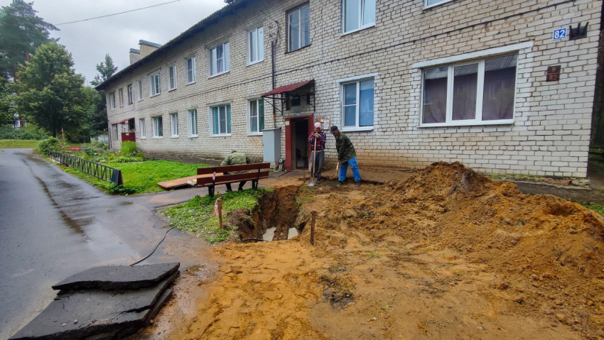 Раскопки и рабочие с лопатами у здания во дворе
