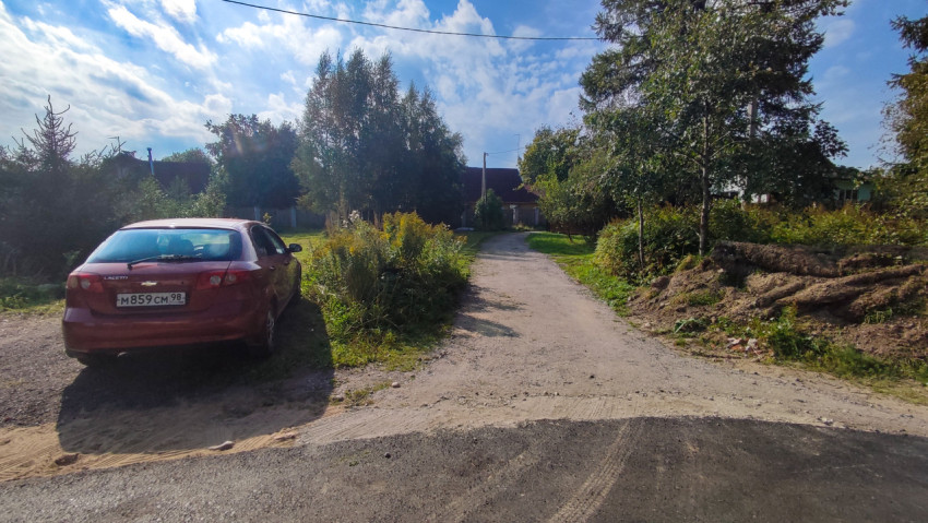 Красный Chevrolet Lacetti у края асфальта и грунтовой дороги