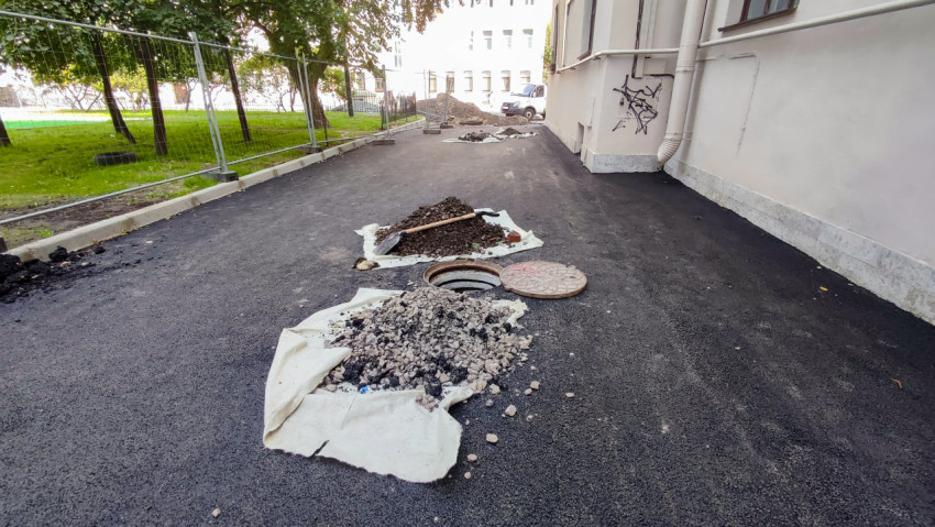 Открытый люк колодца и снятый асфальт при коммунальном ремонте во дворе