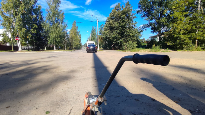 Счётчик измерительного колеса на фоне перекрёстка и пустой проезжей части