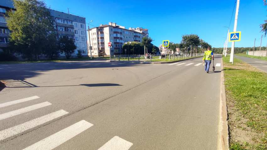 Рабочий меряет улицу курвиметром и уходит по дороге в перспективу