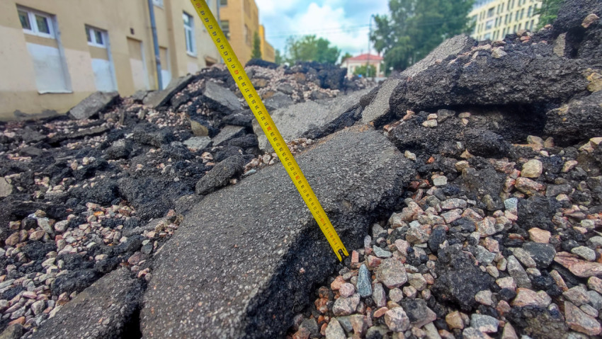Фрагменты снятого асфальта и измерительная рейка в выемке
