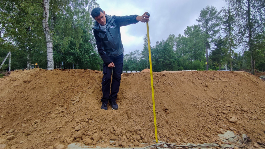 Замер высоты песчаной отсыпки мерной рейкой на благоустройстве