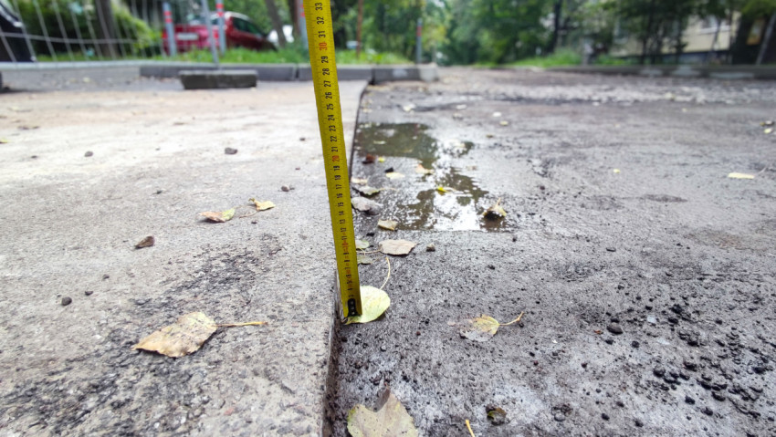 Измерение высоты фрезерованного асфальта рулеткой у бордюра