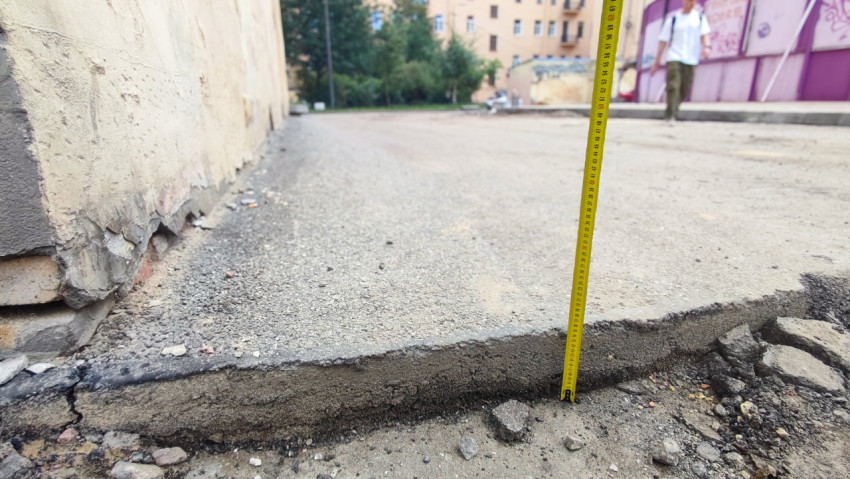 Замер перепада высот по кромке асфальта возле фасада здания в зоне благоустройства