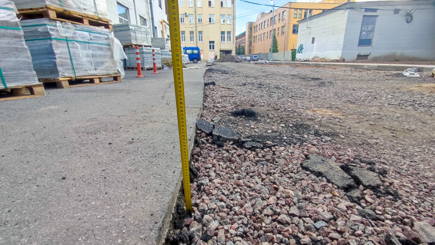 Замер перепада высот у бордюра при ремонте тротуара и подготовке основания