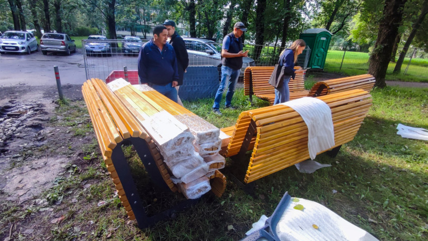 Новые деревянные парковые скамейки в упаковке перед установкой на газоне