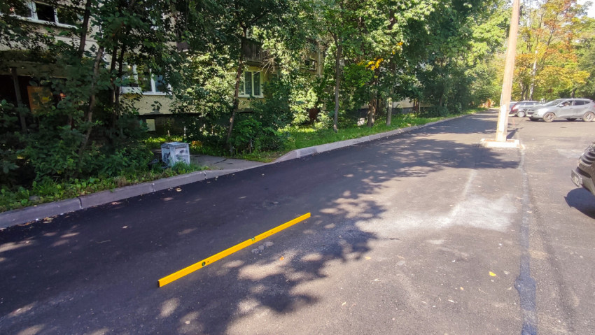 Длинный уровень на дворовой дороге для приёмки ровности асфальтового покрытия