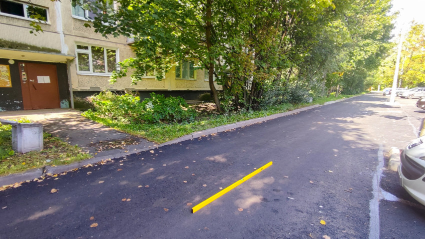 Дворовой проезд у подъезда с уровнем для контроля ровности после асфальтирования